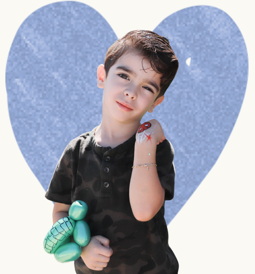 monthly-giving-support.png Child showing off hand paint and a balloon animal at a Variety of the Desert Family Fun event.